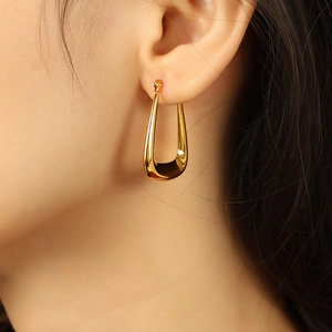 Polished hollow U-shape gold earrings in titanium steel shown on a model for modern style