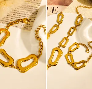Dettaglio di un set di gioielli a catena d'oro con maglie geometriche irregolari e lucide