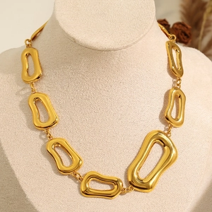 Collana a catena spessa dorata minimalista con grandi anelli irregolari su manichino