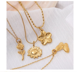 Close-up of 18K gold plated stainless steel necklaces featuring flower and butterfly charms