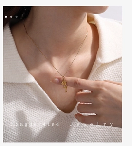 Detailed view of an 18K gold plated rose flower pendant necklace worn by a model
