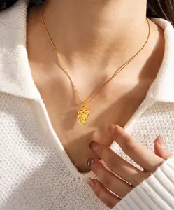 Detail view of 18K gold leaf pendant necklace with realistic veins on female model