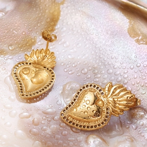 Baroque style gold heart stud earrings with crown detail on a pearlescent shell background