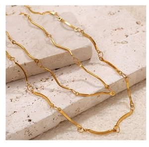 Detail of 18K gold-plated stainless steel chain with wavy links on natural stone