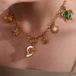 Collar marino dorado con tortuga, estrella de mar y conchas en el cuello de modelo