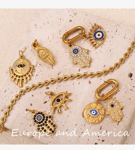 Macro detail of 18K gold-plated Hamsa hand and Evil Eye charms on natural stone
