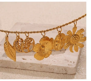 Close-up of assorted 18K gold plated stainless steel botanical pendants with rope chains