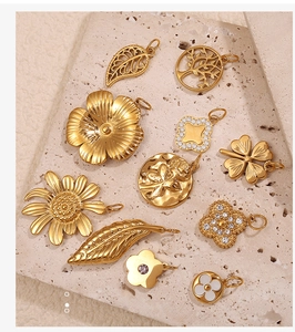 Macro view of detailed 18K gold-plated floral pendants on natural stone texture