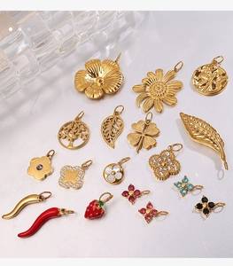 Macro shot of various 18K gold plated charms featuring floral and leaf details