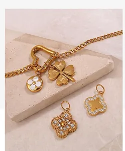 Detail view of 18K gold plated multi-pendant necklace with clover charms and pearl shell disk