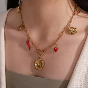 Gold multi-charm necklace with strawberry, chili, and flower pendants on a model