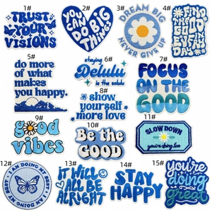 Detailed grid of blue embroidered patches with inspirational English quotes and floral motifs