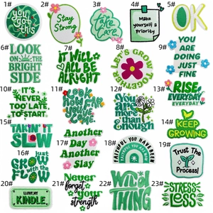 Close-up of 23-piece green motivational embroidery patches for bags and apparel