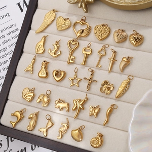 Golden DIY jewelry charms set with starfish, anchors and shells on a velvet tray