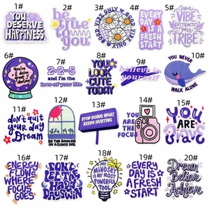 Close-up of assorted purple embroidered motivational letter patches and icons