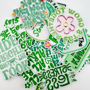 Detailed close-up of green and white embroidered patches with various motivational quotes