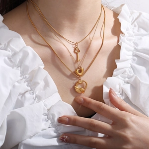 Three-layer gold titanium steel necklace featuring key, heart, and feather charms
