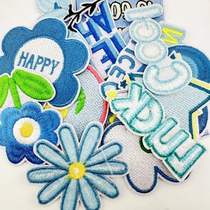Collection of blue floral embroidered patches with Happy and Cool text for clothing repair