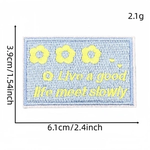 Blue rectangular embroidered patch with yellow flowers and 'Live a good life' text