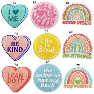 Detail showing nine colorful embroidered patches with rainbow and heart designs in a grid