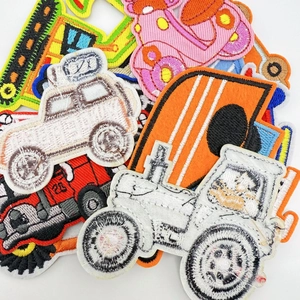 Macro shot of colorful embroidered car patches with tractors and diggers for clothing