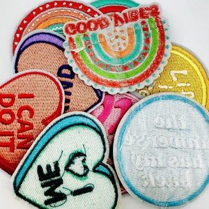 Detailed macro view of colorful embroidered patches with Good Vibes and I Can Do It text