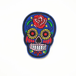 Macro-opname van Mexicaanse suikerschedel borduurpatch met rode rozen en bloemmotieven
