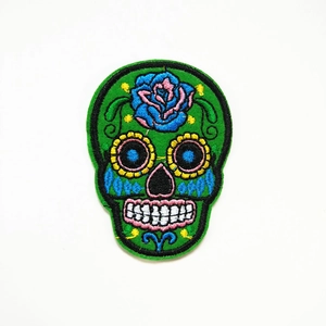 Gedetailleerd borduurwerk van een groene Mexicaanse schedelpatch met bloemmotieven