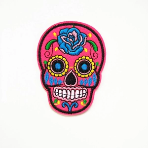 Gedetailleerde macro-opname van een roze suikerschedel patch met blauwe rozen