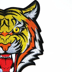 Close-up of high-density tiger head embroidery patch with detailed orange and black threads