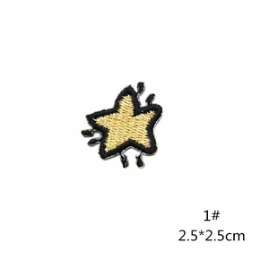 Detail of a 2.5cm gold star embroidered patch with black dripping effect and fine texture