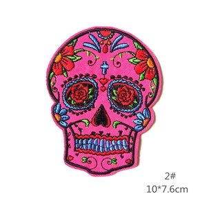 Close-up of sugar skull embroidery patch with roses and floral details in pink