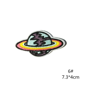 Macro shot of colorful planet embroidery patch with star ring and white border edges