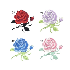 Close-up of four colorful rose embroidery patches in red, blue, pink, and purple shades