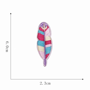 Macro detail of multicolored embroidered feather patch showing 6.0cm by 2.3cm dimensions