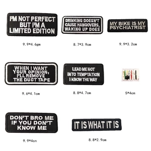 Macro detail of assorted black rectangular embroidered letter patches with white stitching