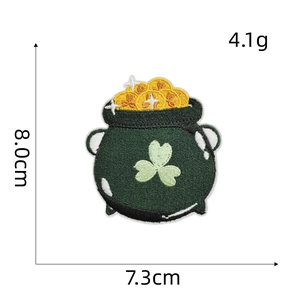Macro detail of St. Patrick's Day pot of gold embroidery patch with green shamrock pattern