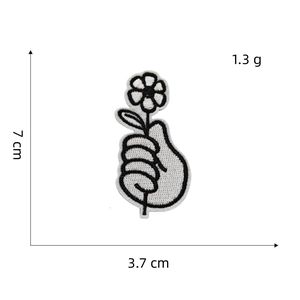 Detail view of black and white hand with flower embroidery patch showing 7cm height scale