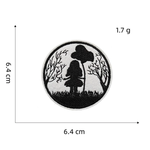 Detail showing a 6.4 cm round black and white embroidered patch with forest girl silhouette
