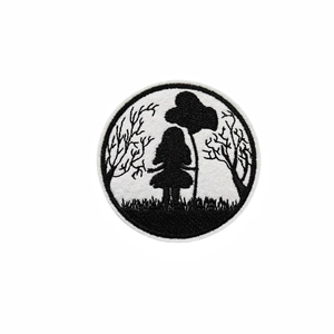 Round embroidered patch featuring a black and white silhouette of a girl with balloons