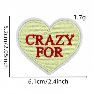 Détail d'écusson brodé en cœur avec dimensions 6,1cm x 5,2cm pour décor de vêtements