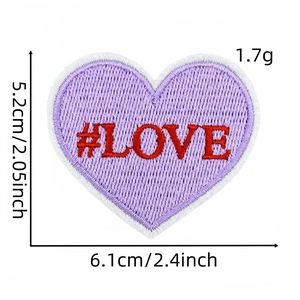 Détail macro d'un écusson cœur brodé violet avec texte LOVE rouge et dimensions