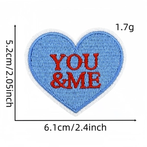 Détail de l'écusson brodé en cœur bleu avec texte YOU & ME et dimensions de 5,2x6,1 cm