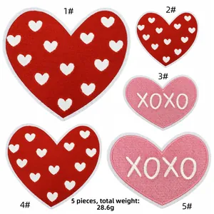 Close-up of pink and red embroidered heart patches with XOXO letters and heat melt glue