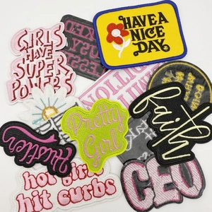 Detailed view of colorful embroidered patches with diverse slogans and floral patterns