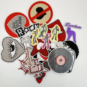 Macro view of rock-style embroidered patches featuring guitar and vinyl motifs