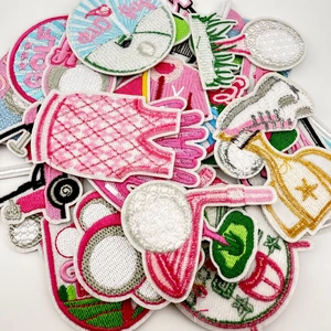 Detailed close-up showing pink cartoon golf embroidery patches with fine needlework texture