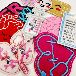Detailed embroidery texture of medical patches including heart, lungs, and brain designs