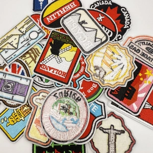 Detailed close-up of embroidered travel patches featuring Berlin, Holland, and Canada landmarks