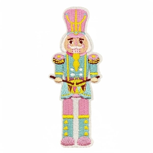 Detailed embroidered nutcracker soldier patch with pink hat and blue uniform on white background